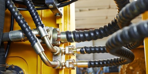 Several different types of DME&JDE hose assemblies with plastic sleeves are installed onto the equipment.